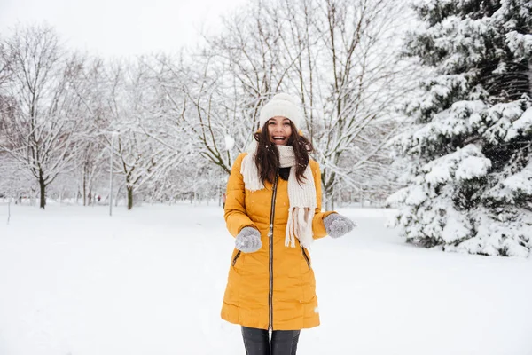 Sorridente signora gioiosa che gioca con la neve in inverno nel parco — Foto Stock