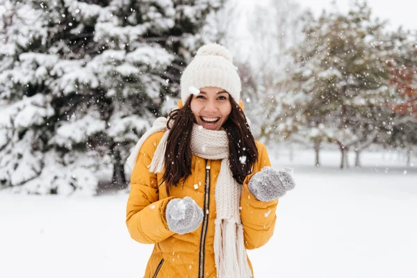 Donna che ride giocando con la neve mentre cammina nel parco — Foto Stock