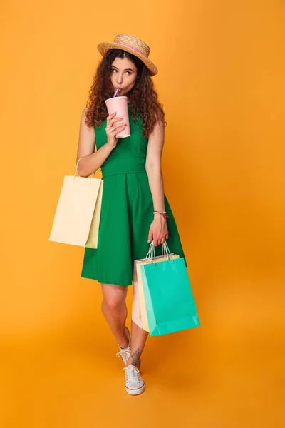 Mulher bebendo água gaseificada segurando sacos de compras . — Fotografia de Stock
