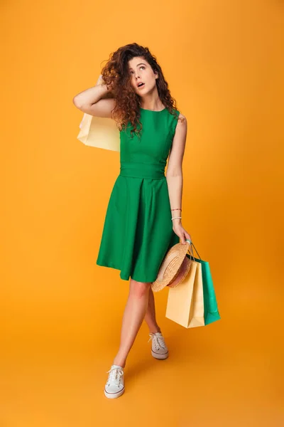 Mujer joven seria sosteniendo bolsas de compras . — Foto de Stock