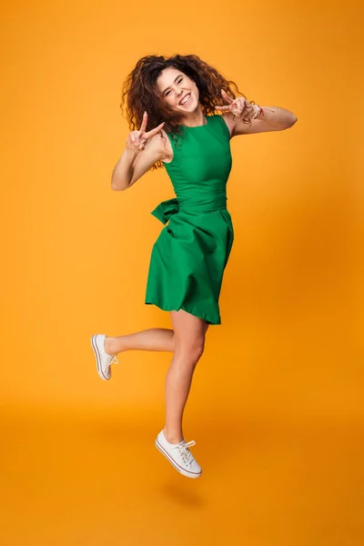 Retrato de longitud completa de una chica excitada de pelo rizado saltando — Foto de Stock