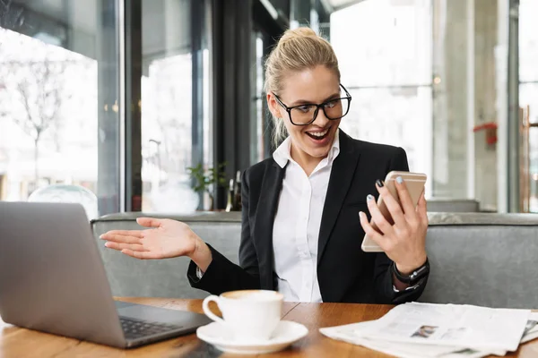 Glückliche blonde Geschäftsfrau sitzt am Tisch im Café — Stockfoto