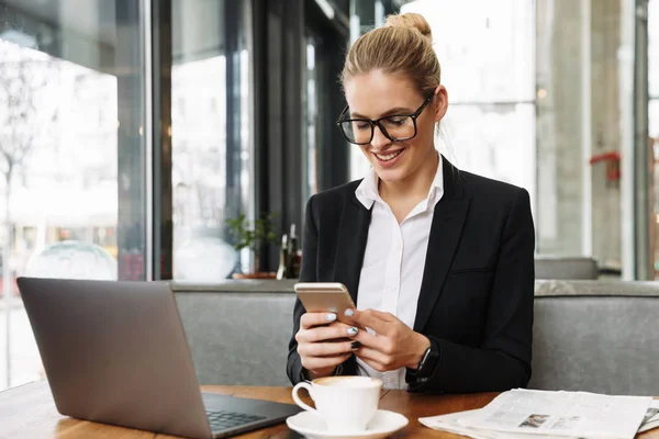 Lächelnde blonde Geschäftsfrau sitzt am Tisch im Café — Stockfoto