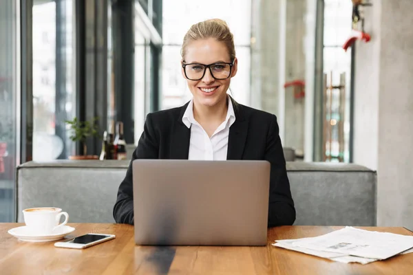 Uśmiechający się biznes blond kobieta siedzi przy stole w kawiarni — Zdjęcie stockowe