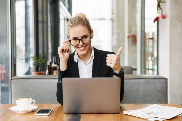 Glückliche blonde Geschäftsfrau sitzt am Tisch im Café — Stockfoto