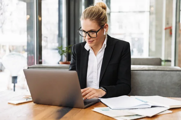 Smiling blonde business woman sitting by the table in cafe — Stock Photo, Image