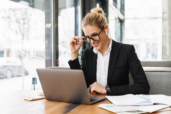 Glückliche blonde Geschäftsfrau sitzt am Tisch im Café — Stockfoto