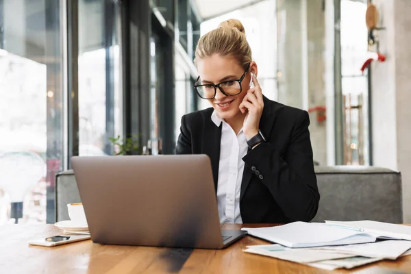 Smiling blonde business woman sitting by the table in cafe — Stock Photo, Image