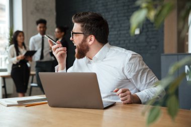 Çığlık genç beyaz işadamı cep telefonuyla konuşurken rahatsız.