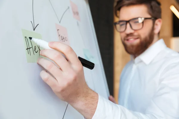 Vrolijke jonge zakenman iets schrijven — Stockfoto