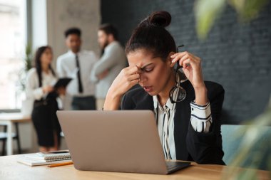 Yorgun genç Afrika iş kadın kapalı dizüstü bilgisayar kullanan oturuyordu.