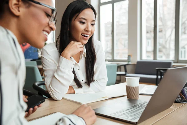 Heureuses jeunes femmes d'affaires excitées utilisant un ordinateur portable . — Photo