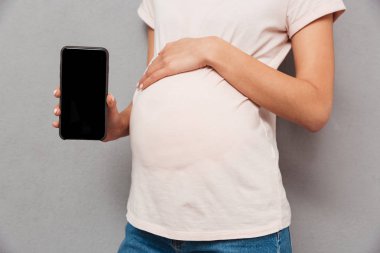 Hamile kadının cep telefonu görüntüsünü gösterilen Resim kırpılmış.