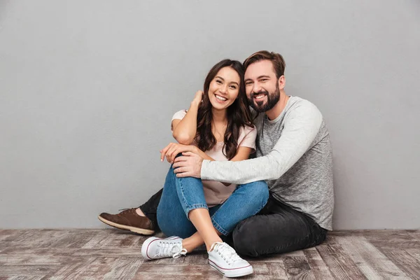 Fröhlicher schöner Mann mit seiner Frau, die isoliert sitzt — Stockfoto