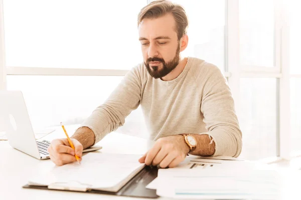 Bild eines smarten erwachsenen Mannes in lässiger Kleidung, der Notizen schreibt — Stockfoto