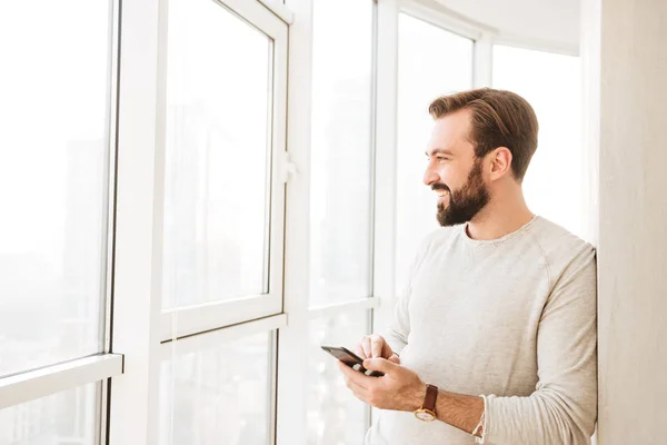 Communicative guy with beard and mustache, looking through big w — Stock Photo, Image