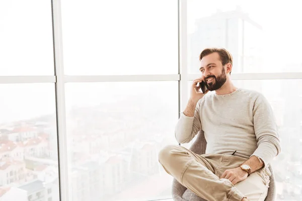 Tipo sociable con barba y bigote mirando a través de una ventana grande , — Foto de Stock