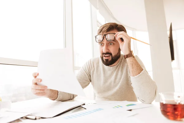 Portret van een geschokt man werken met documenten — Stockfoto