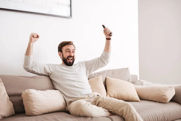 Portrait d'un homme excité tenant la télécommande — Photo