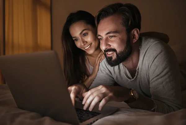 Retrato de una feliz pareja joven usando un ordenador portátil — Foto de Stock