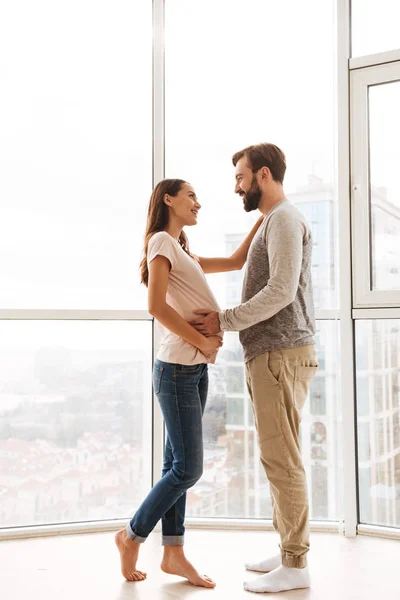 Feliz grávida jovem casal abraçando — Fotografia de Stock