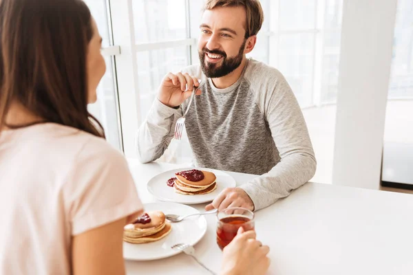 Leende unga par med frukost — Stockfoto