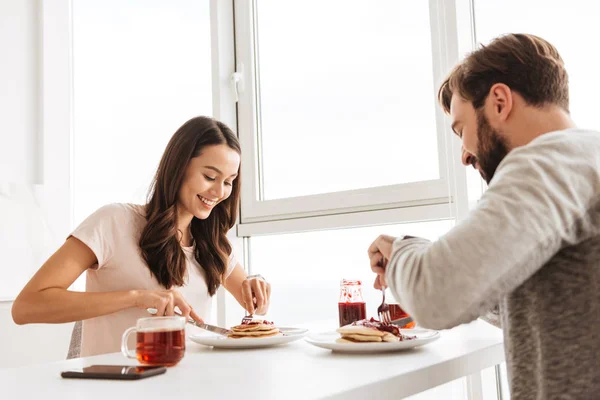 Beautiful young couple having breakfast while sitting together — Stock Photo, Image