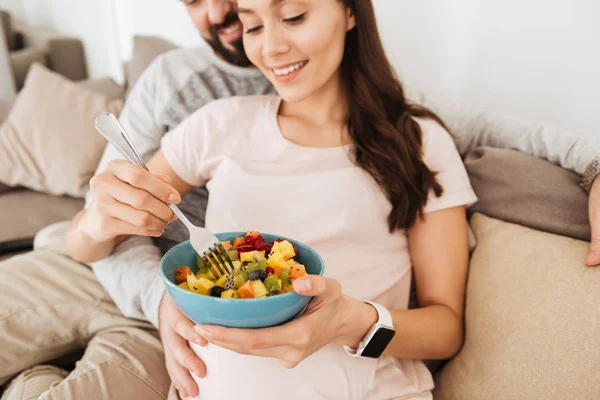 Обрізане зображення усміхненої молодої вагітної пари розслабляється — стокове фото