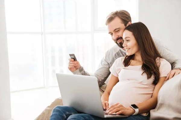 Πορτρέτο του ένα ευτυχισμένο ζευγάρι νεαρή έγκυος που online αγορές — Φωτογραφία Αρχείου