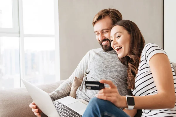 Retrato de um jovem casal rindo compras on-line — Fotografia de Stock