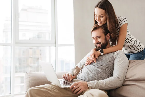 Retrato de una joven pareja sonriente usando un ordenador portátil — Foto de Stock