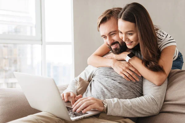 Retrato de una feliz pareja joven usando computadora portátil — Foto de Stock