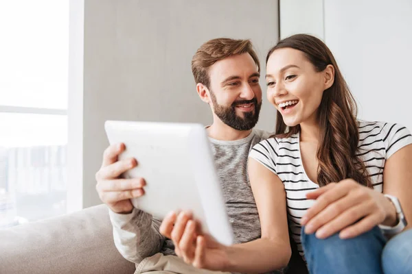 Retrato de una alegre pareja joven usando tableta —  Fotos de Stock