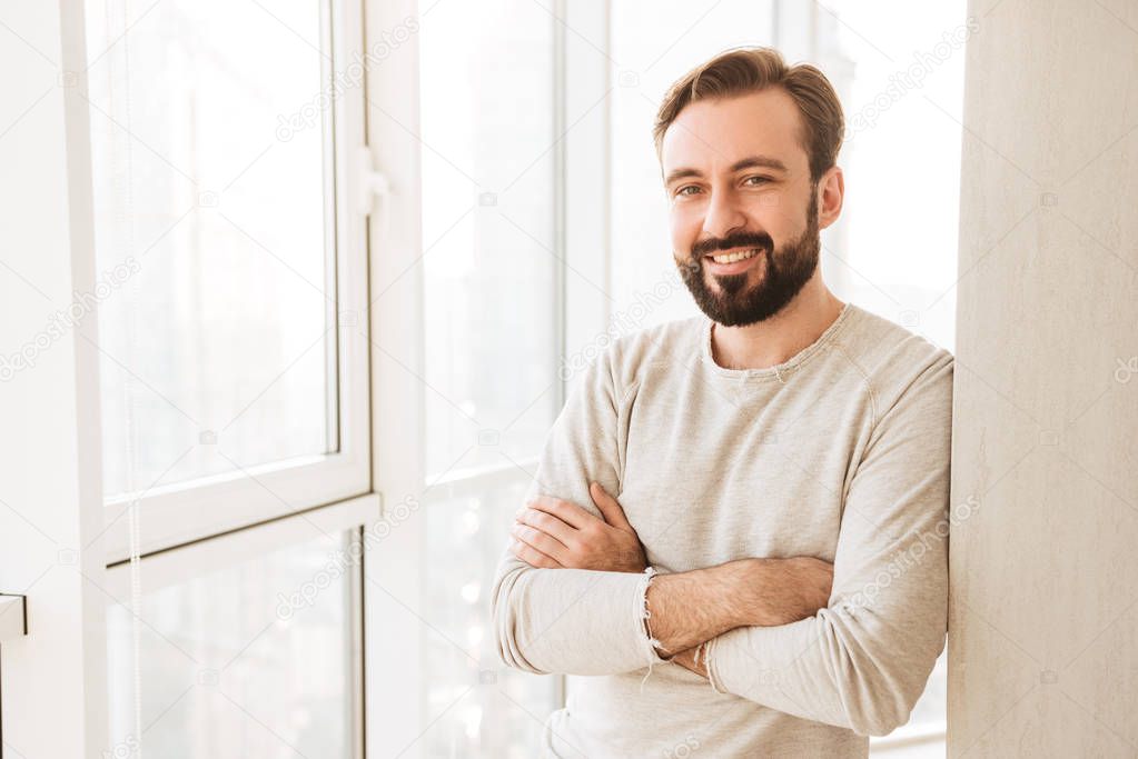 Portrait of smiling guy 30s having beard and mustache, standing 