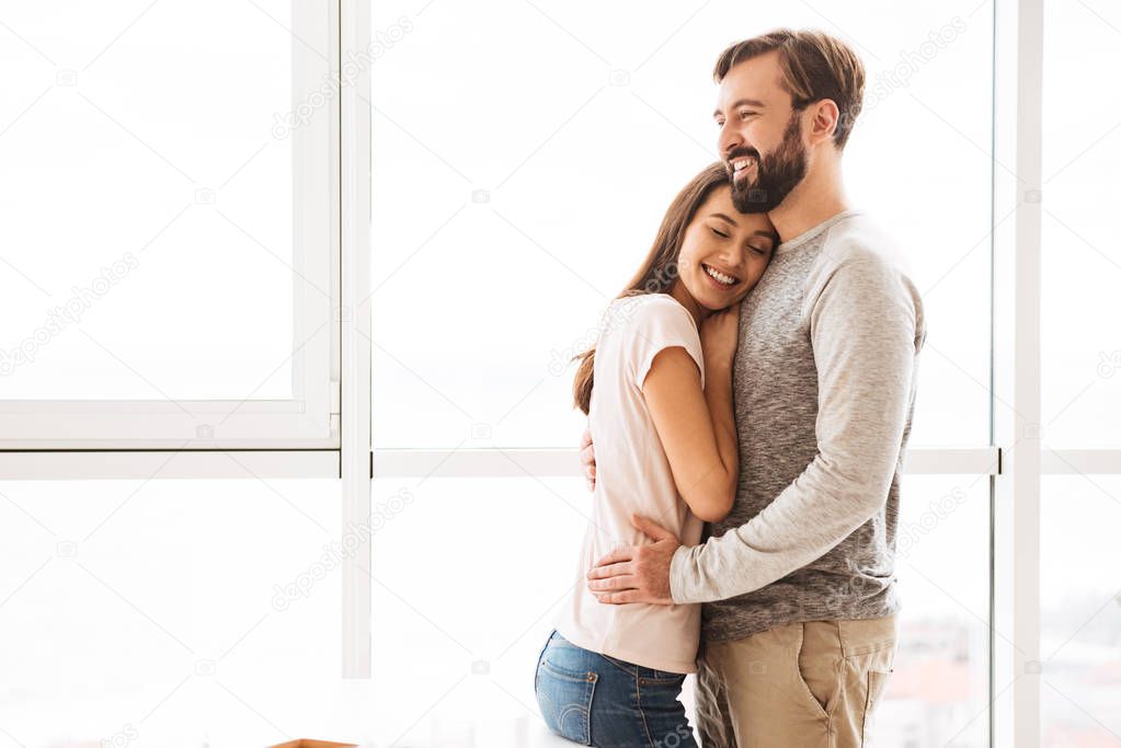 Smiling young couple embracing while standing