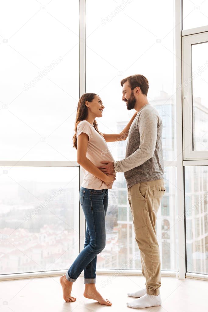 Happy pregnant young couple hugging