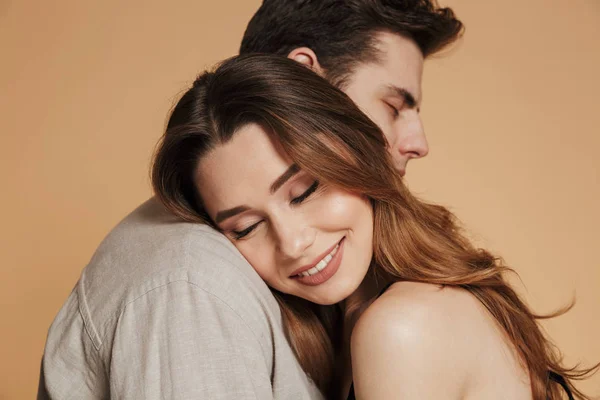 Fröhliche brünette Frau liegt auf der Schulter ihres Mannes und genießt — Stockfoto