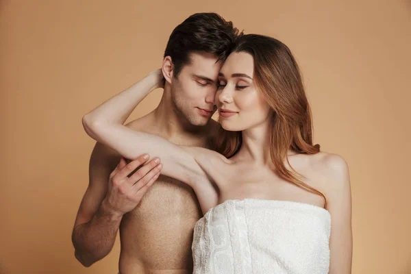 Молодой мужчина без рубашки держит и обнимает свою женщину в изоляции — стоковое фото