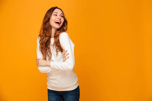 Vrolijke brunette vrouw trui kijken weg met gekruiste armen — Stockfoto