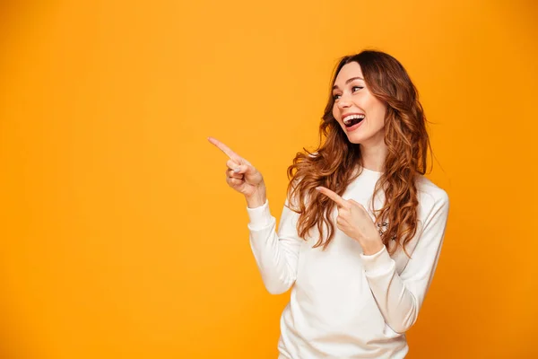 Mooie leuke jonge vrouw wijzend. Op zoek naar opzij. — Stockfoto