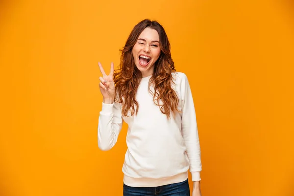 Veselá brunetka žena v svetr ukazující mírové gesto — Stock fotografie