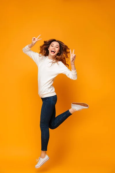 Full length image of Cheerful brunette woman in sweater jumping — Stock Photo, Image