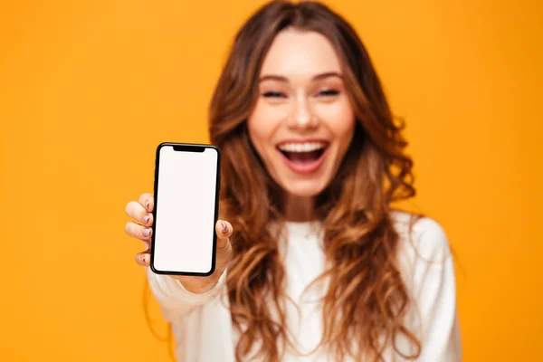 Mulher morena feliz em suéter mostrando tela de smartphone em branco — Fotografia de Stock