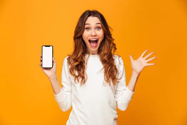 Choqué femme brune heureuse en pull montrant smartphone vide — Photo