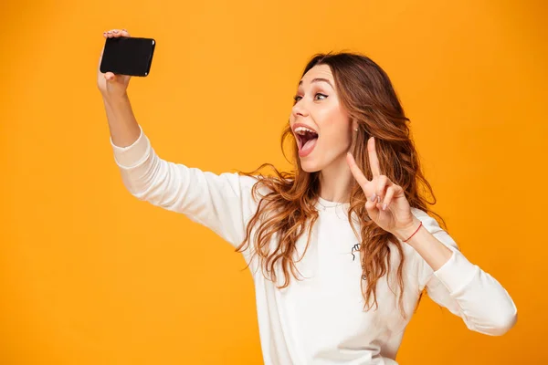 Glad brunett kvinna i tröja att göra selfie på smartphone — Stockfoto