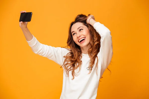 Emotionale junge Frau macht Selfie per Handy. — Stockfoto