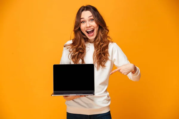 惊奇的愉快的妇女在毛衣显示空白笔记本电脑屏幕 — 图库照片