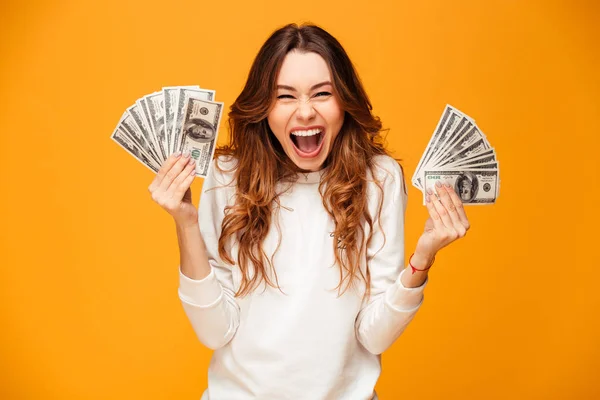 Feliz gritando morena mujer en suéter celebración de dinero y se regocija —  Fotos de Stock