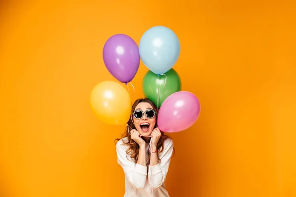 Szczęśliwy brunetka dama w sweter i okulary gospodarstwa balony — Zdjęcie stockowe