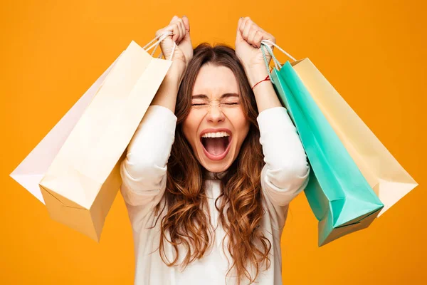 Glada skrikande brunett kvinna i tröja holding paket — Stockfoto